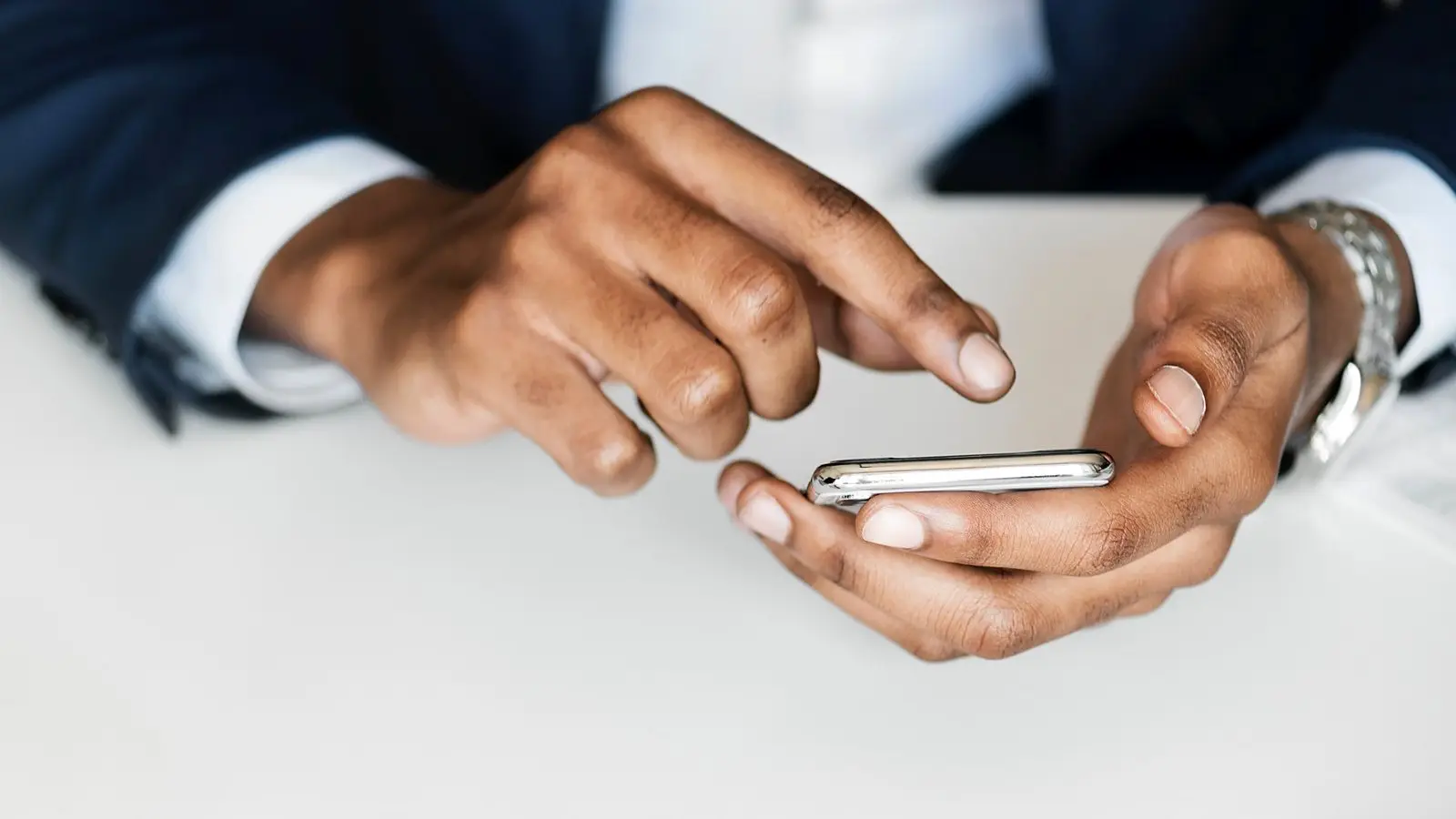 Hands using a smartphone, the way staff clock in from their phones