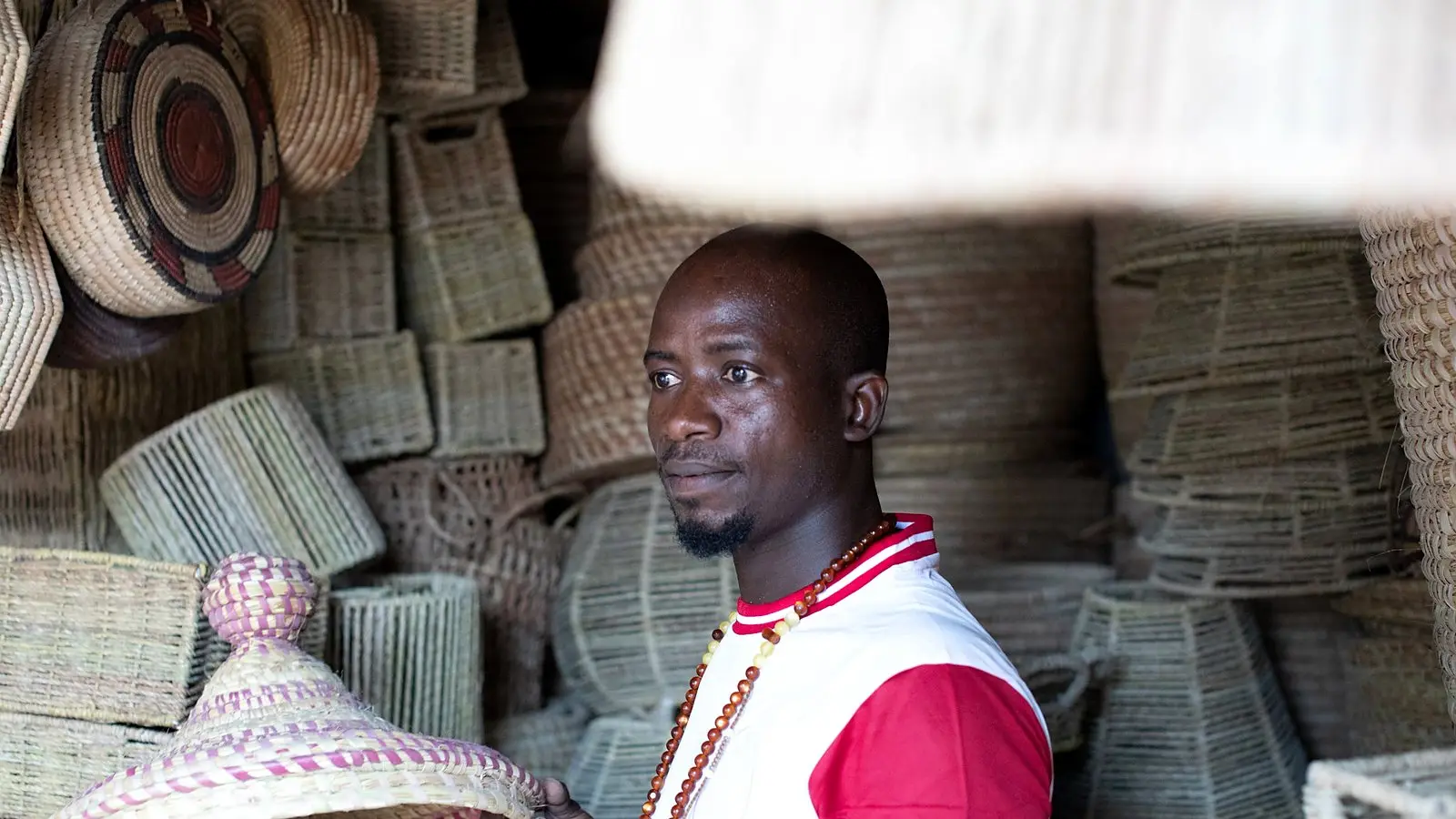 A trader surrounded by woven baskets at a West African market